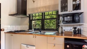 Una cocina moderna con estufa a gas, pileta doble, electrodomésticos de acero inoxidable y lavavajillas.