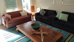 Ein Wohnzimmer mit zwei Sofas, einem Couchtisch und einem gemusterten Teppich.
