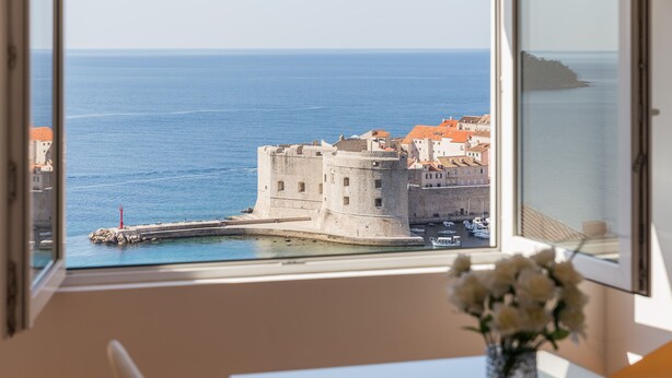 A room with a large window overlooking a historic fort and the sea. - Apartment  Bellissima vista (Dubrovnik)