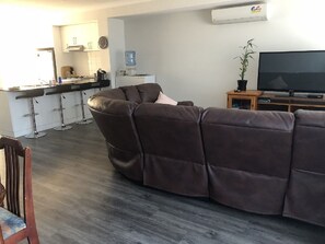 Relax in this spacious living area with a comfortable sofa, kitchenette, and flat-screen TV.