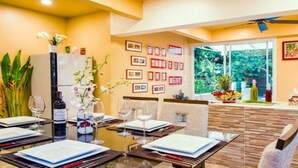 A dining area with a table set for four, a refrigerator, and a window with a view of greenery. - VERY PEACEFUL "EDEN GATE VILLA" CENTRAL CHIANG MAI (Chiang mai)