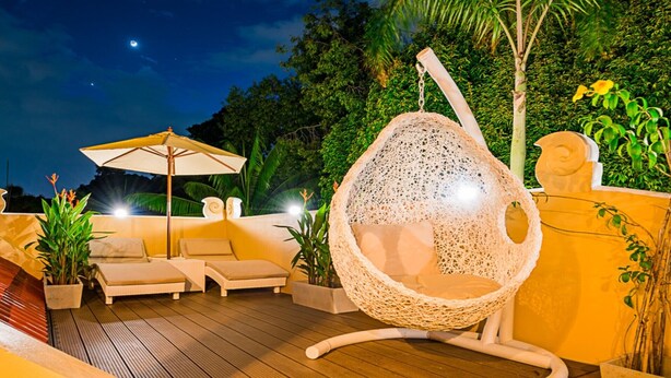 A deck with lounge chairs and a hanging chair, surrounded by greenery and a night sky. - VERY PEACEFUL "EDEN GATE VILLA" CENTRAL CHIANG MAI (Chiang mai)