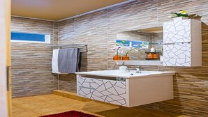 A modern bathroom with a tiled floor, a white sink with a geometric backsplash, a towel hanging on a rack, and a mirror above the sink. - VERY PEACEFUL "EDEN GATE VILLA" CENTRAL CHIANG MAI (Chiang mai)