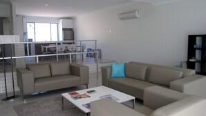 A modern living room with two sofas, a coffee table, and a dining area in the background. - Quiet Getaway Only Minutes to Beach (Encounter Bay)
