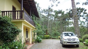 A house with a balcony, a gravel driveway, and a parked car. - Charming Swiss house! (V Matilde)