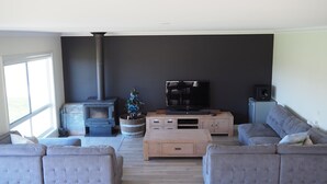 A living room with a fireplace, a television, and a sofa. - Jackaleah Farm  Stay Oxley (Oxley)