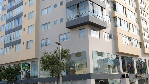 A multi-story hotel with balconies, large windows, and a ground-level retail space. - Miraflores Nest - Alcanfores (Miraflores)