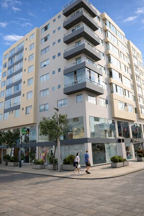 A multi-story hotel with balconies, large windows, and a ground-level retail space. - Miraflores Nest - Alcanfores (Miraflores)