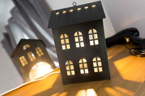 A wooden house-shaped lantern with multiple windows, placed on a wooden surface.