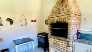 Una cocina con horno de ladrillo, una mesa y una estufa a gas.