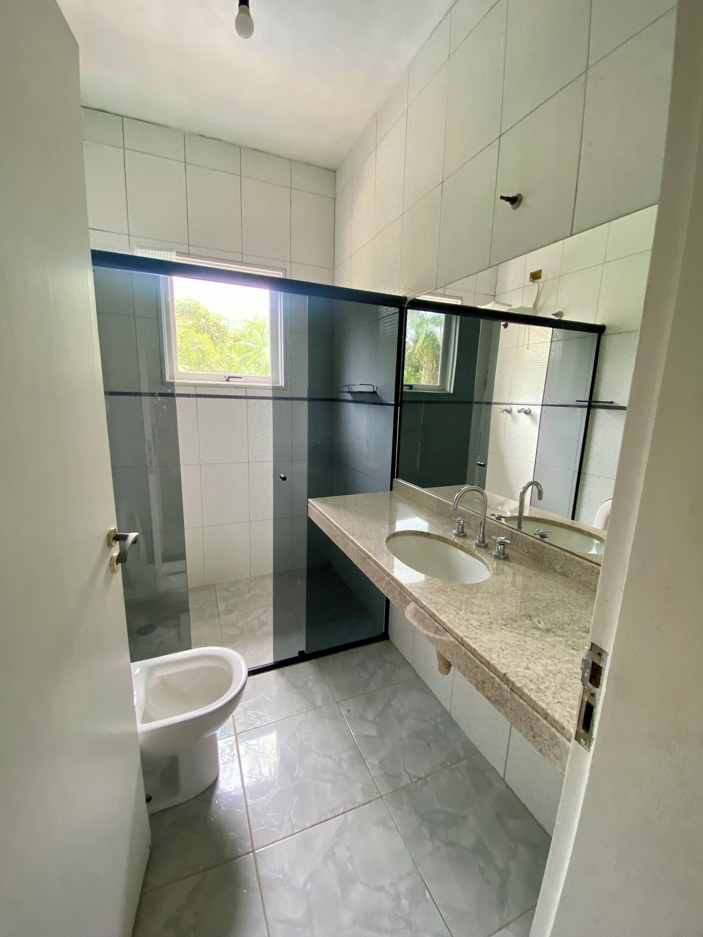 Baño con inodoro, bidé y lavabo con espejo.
