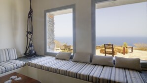 Ein Zimmer mit einer Sitzbank vor einem großen Fenster mit Blick auf eine reizvolle Landschaft.