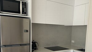 Una cocina compacta con microondas, horno y tostadora integrados.