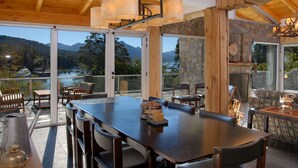 Un comedor amplio con una mesa grande y sillas, una cafetera y un objeto decorativo sobre la mesa.