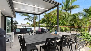 An outdoor patio area with a dining table, chairs, and a sofa. - Graebill - Light & Spacious Duplex (SUNSHINE BEACH)