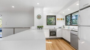 Enjoy cooking in this well-equipped kitchen with a large island, oven, and modern cabinetry.