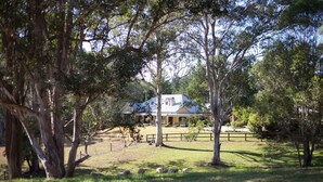 A house surrounded by trees in a grassy area.