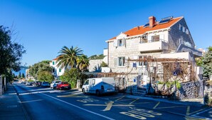Una calle con una parada de autobús y coches estacionados.