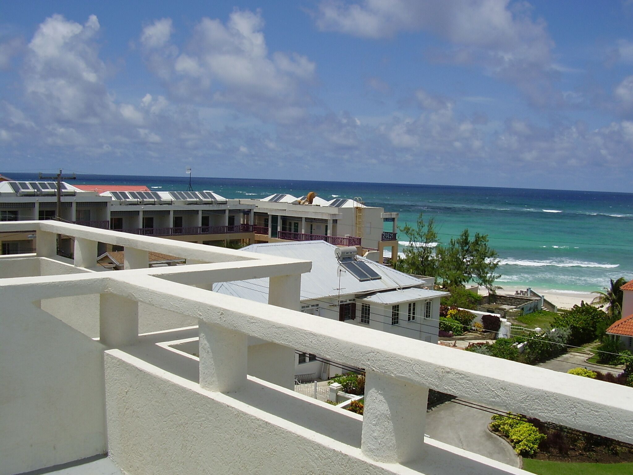 Un hôtel situé sur la côte, composé de plusieurs bâtiments, doté de balcons et offrant une vue sur l’océan.