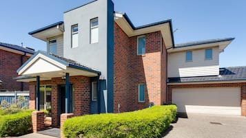 A modern two-story house with a garage, a covered entryway, and a well-maintained front yard.