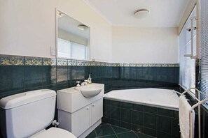 A bathroom with a toilet, sink, and bathtub.