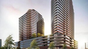Two modern high-rise buildings with curved balconies and a glass facade.