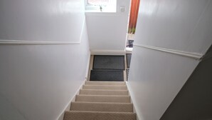 Ein Teppichgesteiger mit einer Zwischenebene, ausgestattet mit Fußmatte und einem kleinen Fenster.