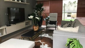 Uma sala de estar moderna com televisão de tela plana, sofá, mesa de centro e tapete de couro de vaca.