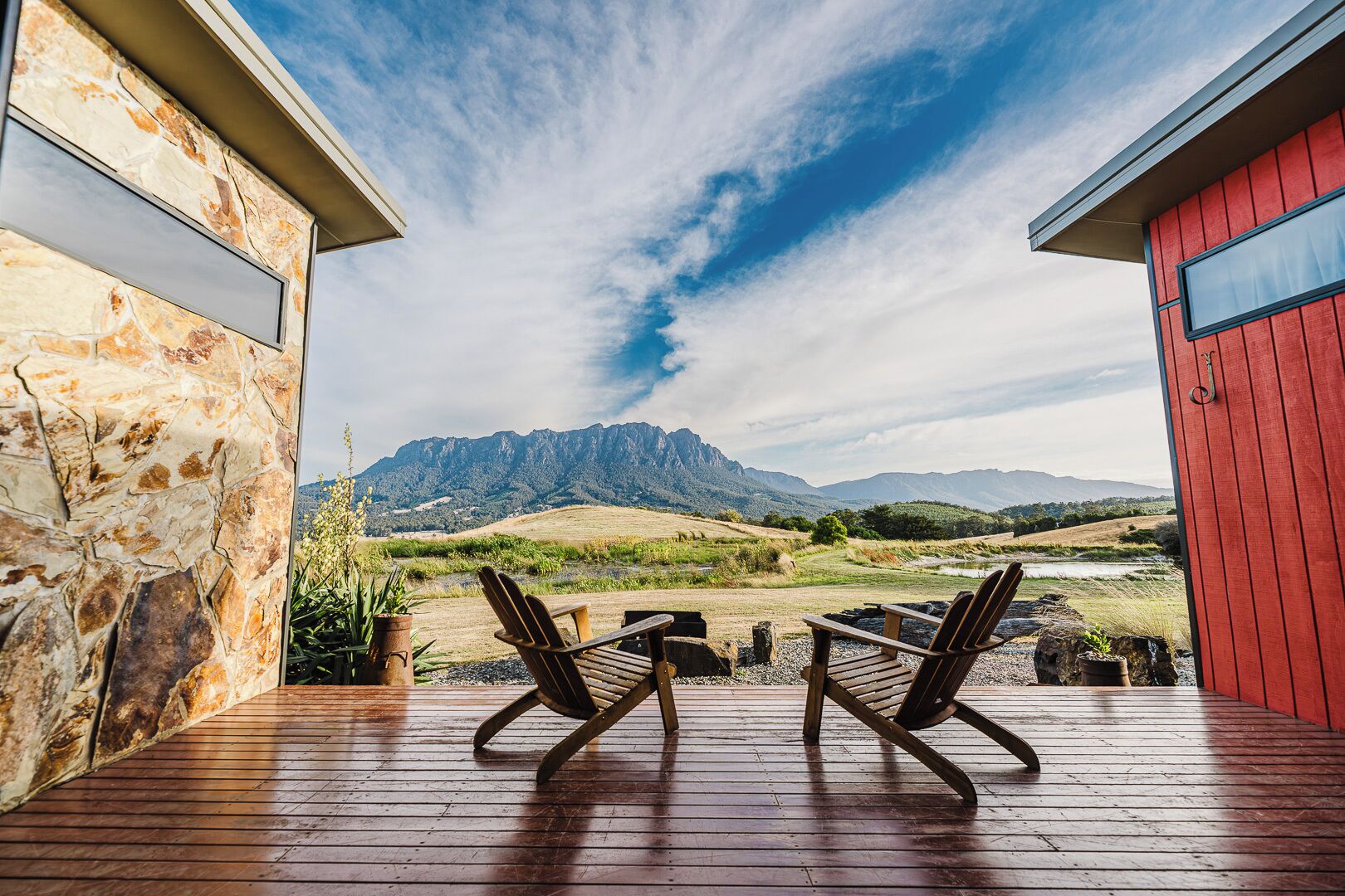 Eine Holterrasse mit zwei Stühlen, die auf eine Berglandschaft ausgerichtet ist.