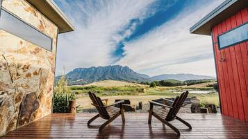 Eine Holterrasse mit zwei Stühlen, die auf eine Berglandschaft ausgerichtet ist.