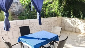 A patio with a table covered by a blue cloth, surrounded by wicker chairs. - Cozy apartment for 4 (Marina)