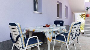 A table set with chairs and a tablecloth, a window, and a potted plant. - Cozy apartment for 4 (Marina)