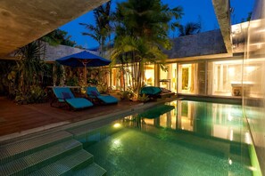 A pool area with lounge chairs and a staircase leading into the water. - Villa C88 Seminyak - Next to Potato Head. (Kuta Utara)
