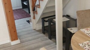 A staircase with wooden railings leading to a landing. A dining table with chairs is positioned near the staircase. - in a quiet position,close to sea 1 (ZADAR)