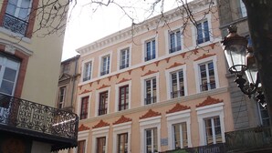 A multi-story building with ornate balconies and a classic architectural style.