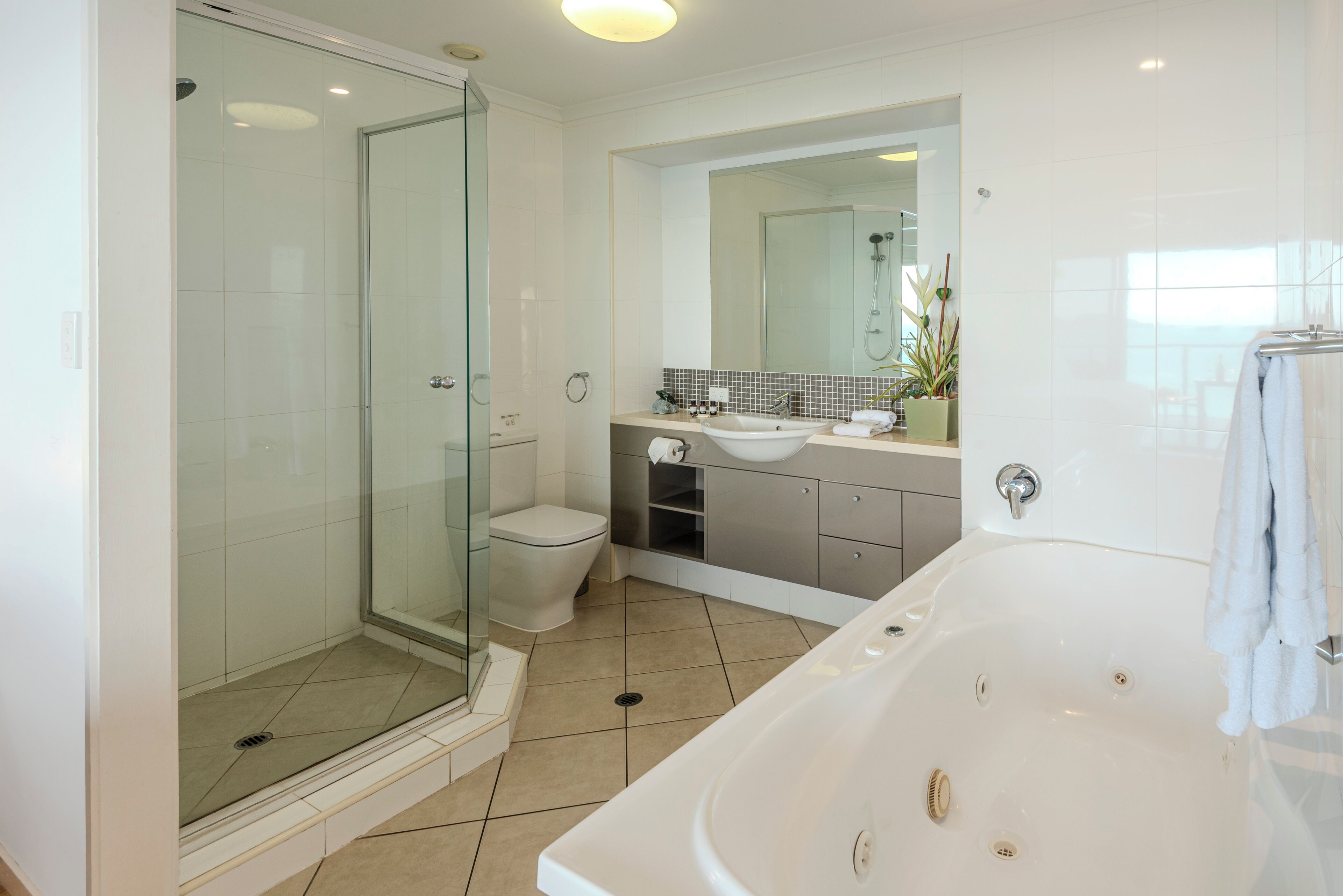 A modern bathroom with a glass-enclosed shower, a toilet, a sink, and a bathtub.