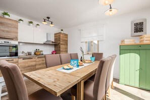 Une cuisine moderne avec une table, des chaises et des placards en bois.