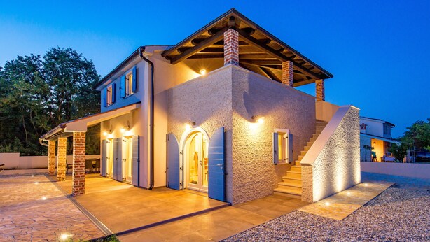 A modern two-story house with a stone facade, a covered porch, and a well-lit entrance. - Villa Leticia a perfect place for relaxed and complete vacation (Hreljići)