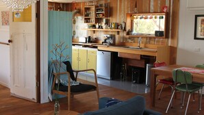 Eine gemütliche Küche mit Holzausstattung, einer Kaffeemaschine und einem Essbereich mit Tisch und Stühlen.