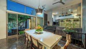 Un espace repas moderne, doté d’une grande table, de chaises et d’un élément décoratif central.