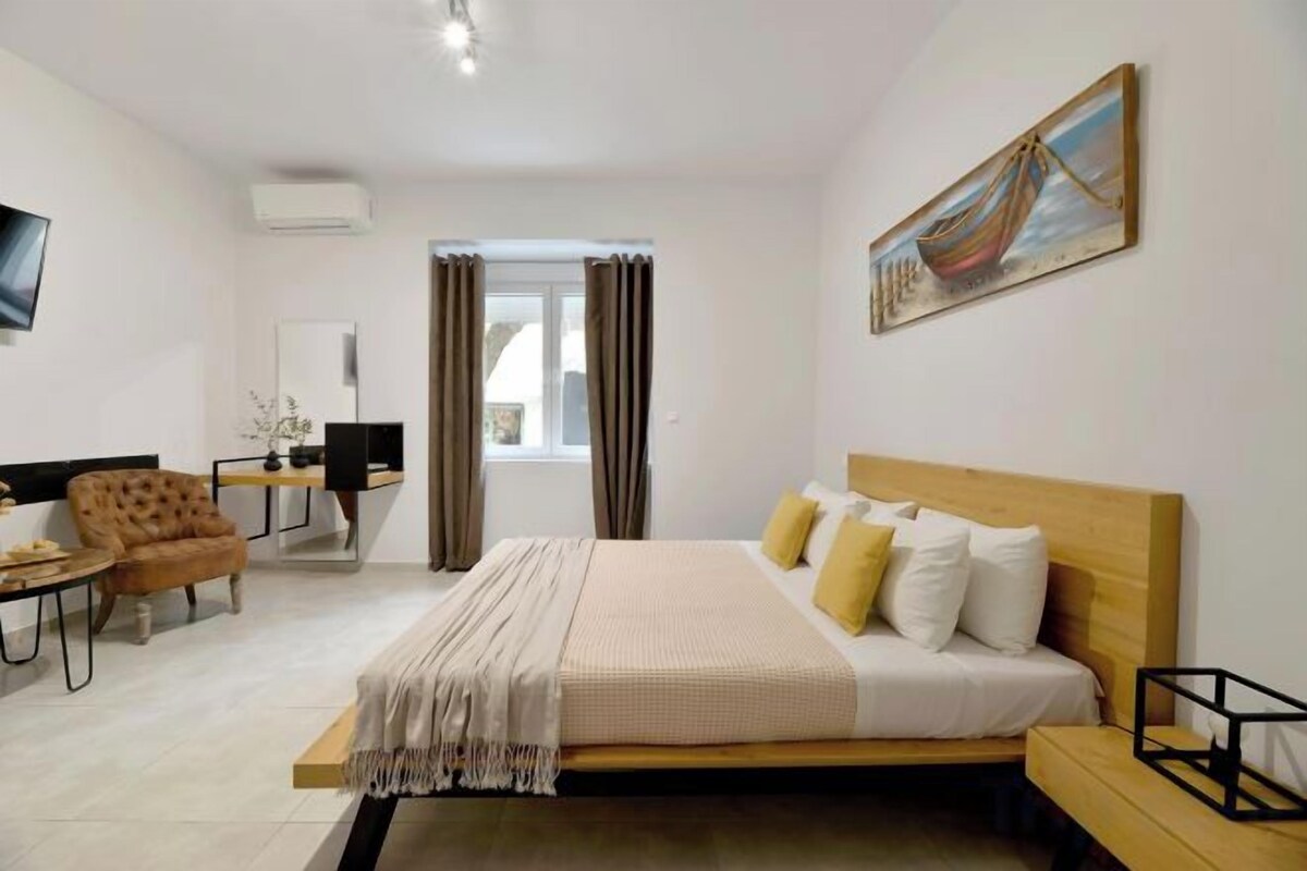 A bedroom with a bed, a desk, a chair, and a television.