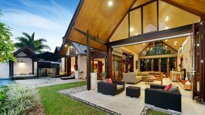 Una casa moderna con un ampio patio arredato e una piscina.