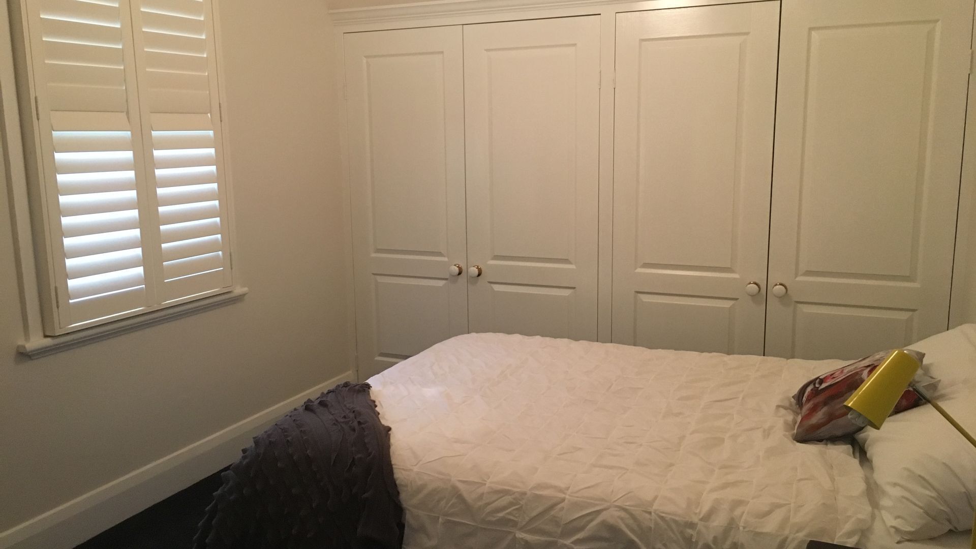Une chambre à coucher avec un lit, des rideaux blancs et une fenêtre.
