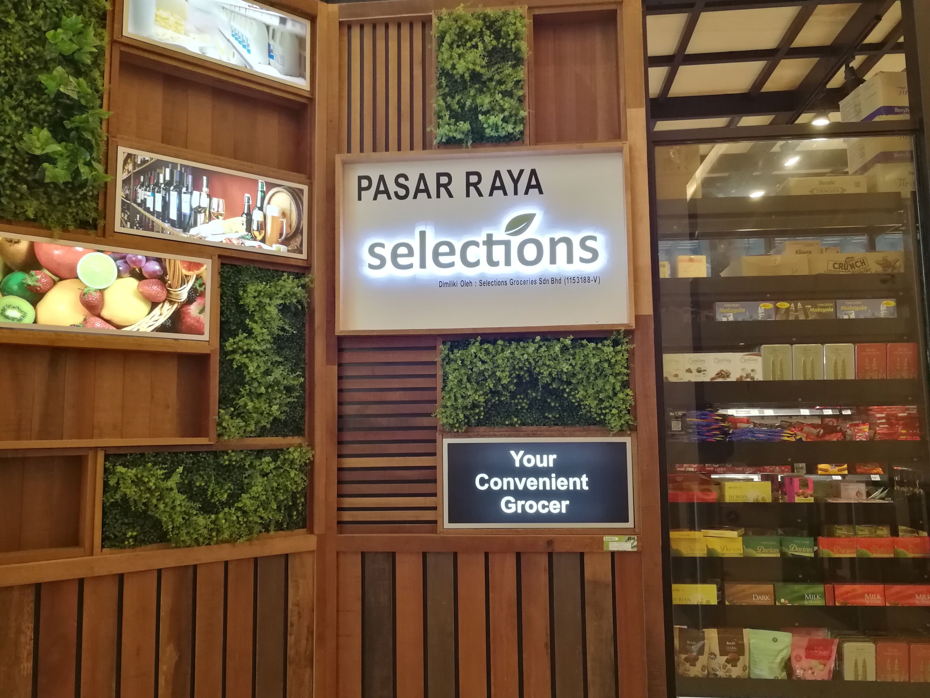 Ein Lebensmittelgeschäft-Interieur mit Holzböden und einem Schild mit der Aufschrift 'PASAR RAYA selections'.