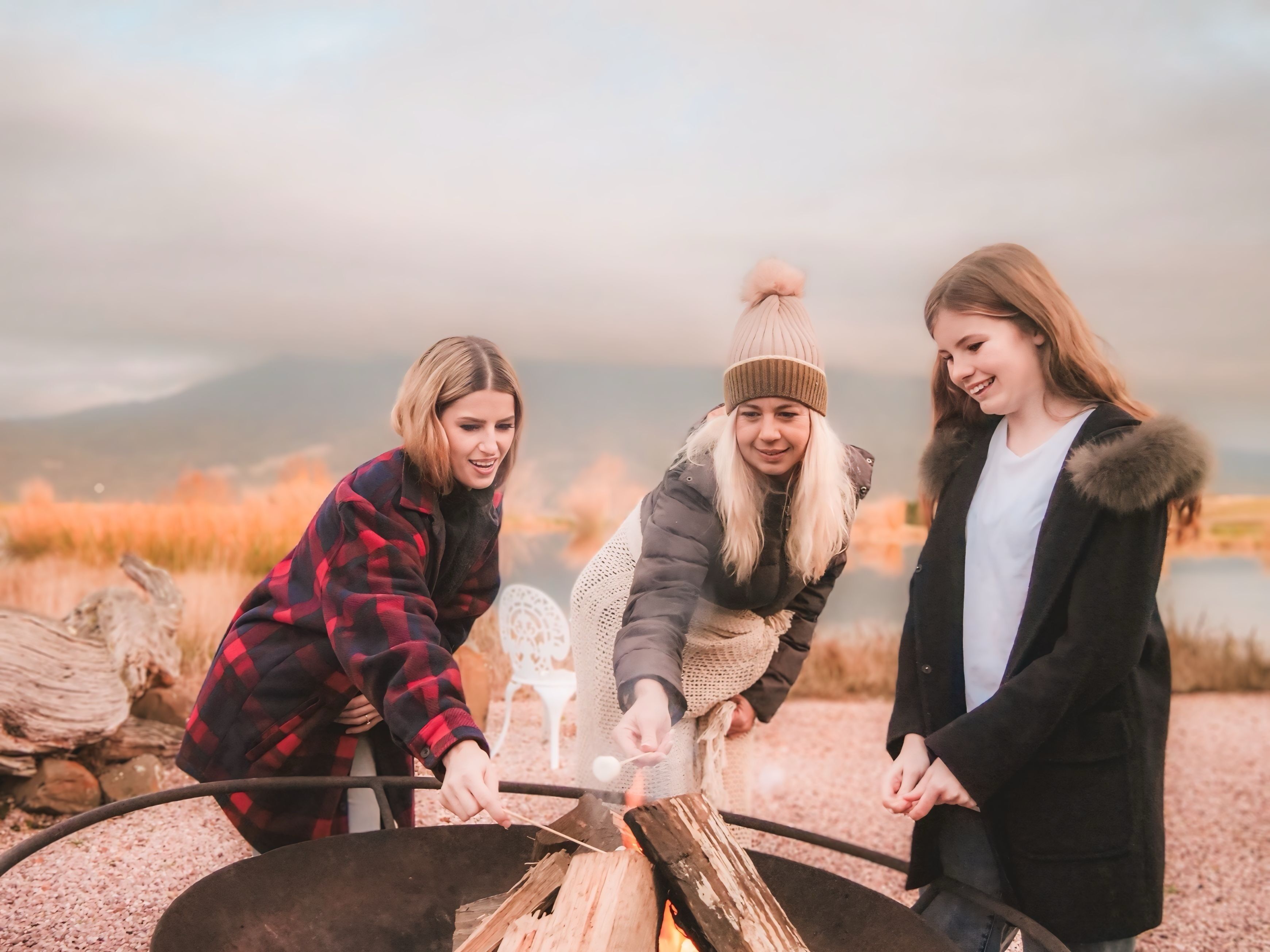 Three people around a campfire.