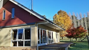 A two-story house with a red roof, large windows, and a covered porch. - Timbarra Hideaway - the perfect retreat (Buchan)