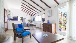 Un'ampia zona giorno con un tavolo da pranzo, un divano e un armadietto in legno.