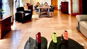 En rummelig stue med spisebord, stole, loftventilator og sofa.