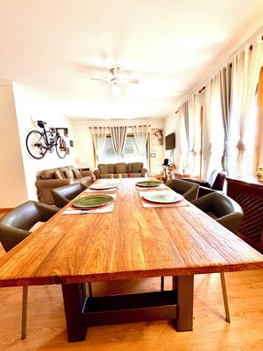 Un espace repas comprenant une table en bois, des chaises et un canapé.