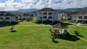 A residential area with multiple two-story houses, a central gazebo, and a well-maintained lawn. - Jamaica Escape 2 Bedroom  Modern Apt. near beaches attractions & restaurants (Ocho Rios)